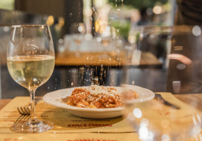 A plate with pasta and a glass of wine